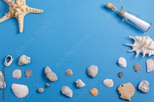 Sea shells and starfish in a bottle on a turquoise background. Place under your text.