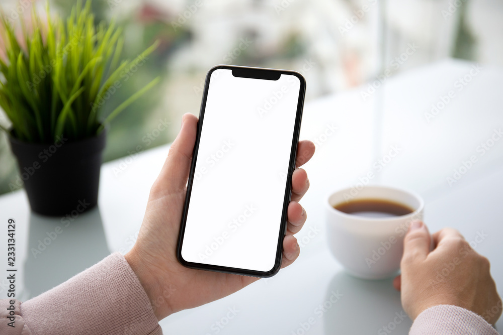 female hand holding touch phone with isolated screen in cafe female hand holding touch phone with isolated screen in cafe