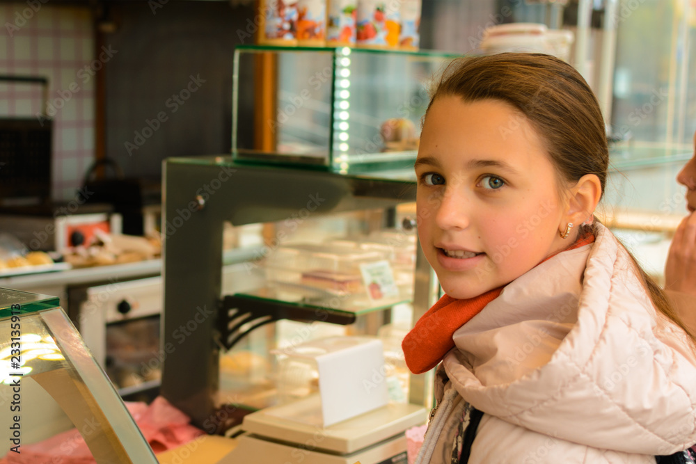 A girl in a street shop buys Belgian waffles