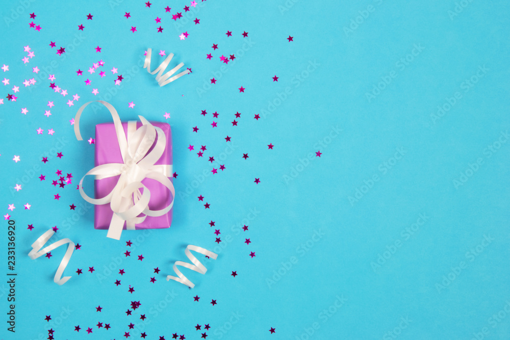 Purple Gift with wViolet gift with a white bow on a blue background.hite bow with sparkles. Purple Gift with wViolet gift with a white bow on a blue background.hite bow with sparkles.