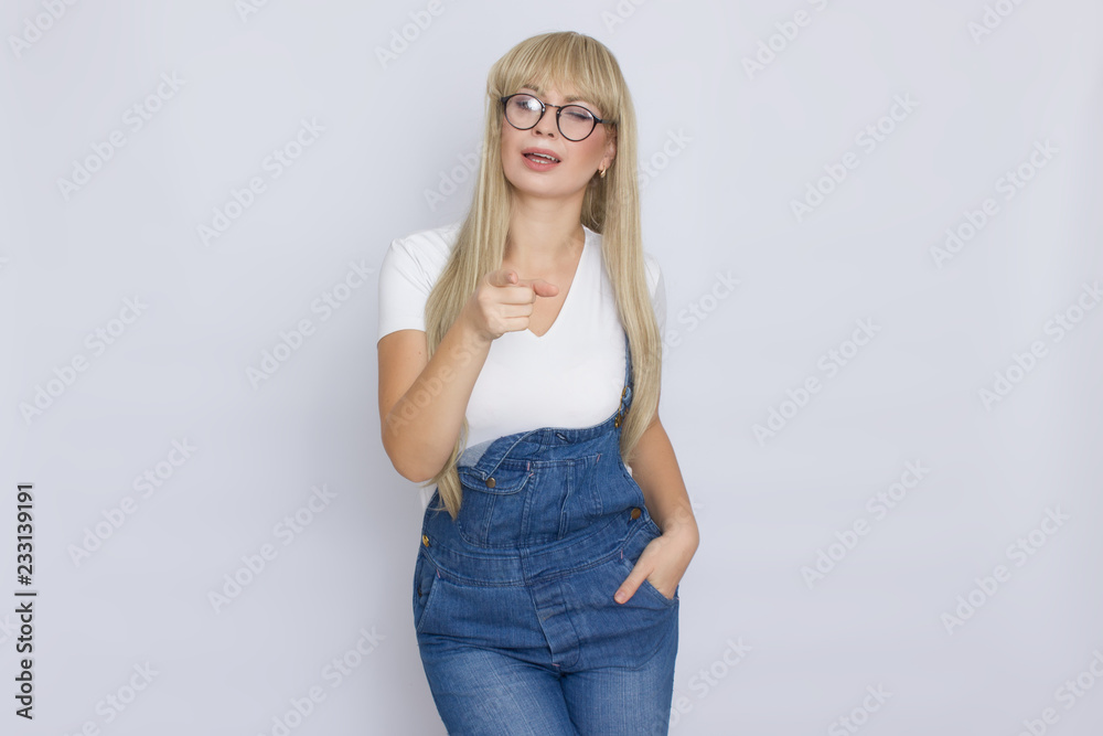Young blond woman in jeans overalls and glasses Young blond woman in jeans overalls and glasses