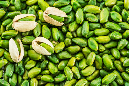 Lot of green pistachio nuts. Food background. photo