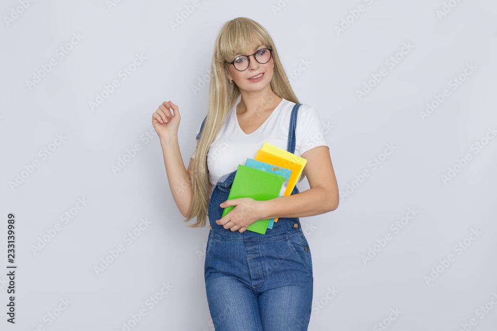 Blond woman in denim overalls with books in her hands Blond woman in denim overalls with books in her hands