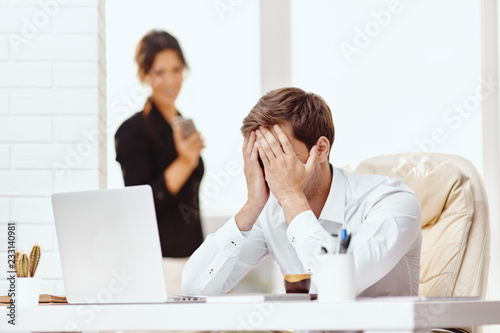 Caucasion man and woman working together in a modern office