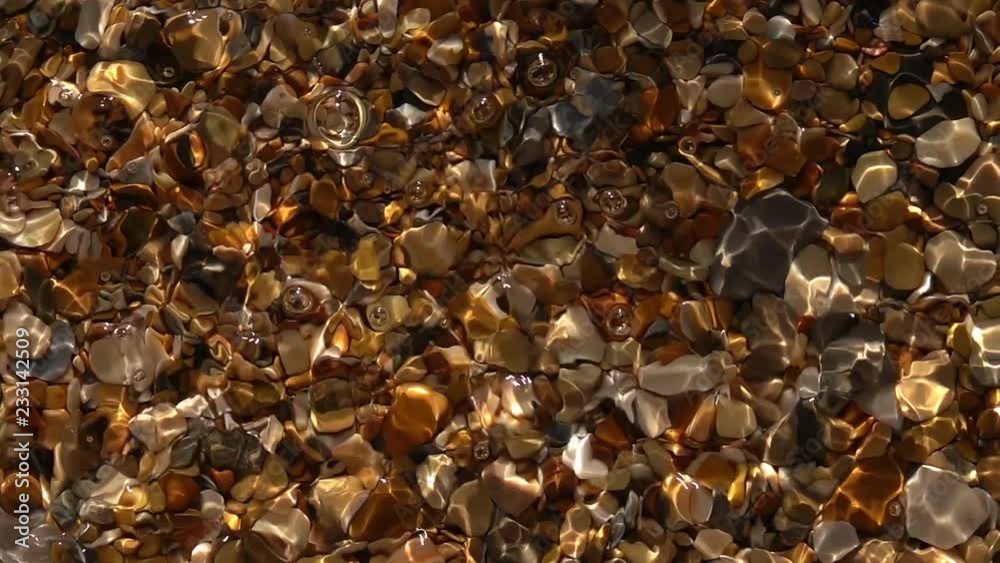 Slow motion of small standing waves with play of sun light in shallow pure water with shingle bottom close up. Amazing natural background with vibrant texture in sun shine. High speed camera shooting. Slow motion of small standing waves with play of sun light in shallow pure water with shingle bottom close up. Amazing natural background with vibrant texture in sun shine. High speed camera shooting.