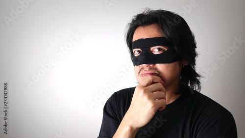 Robber man with black mask thinking about plotting for robbery, Thief robbery concept