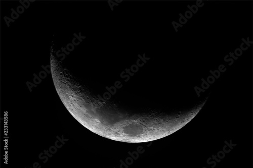 Close up of waxing crescent Moon with craters details, at 1500 mm of focal length, taken with telescope with dark background.