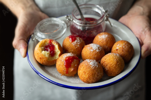 donuts with raspberry jam in male hands.