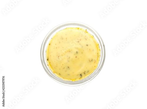 Tasty yellow sauce in bowl on white background photo