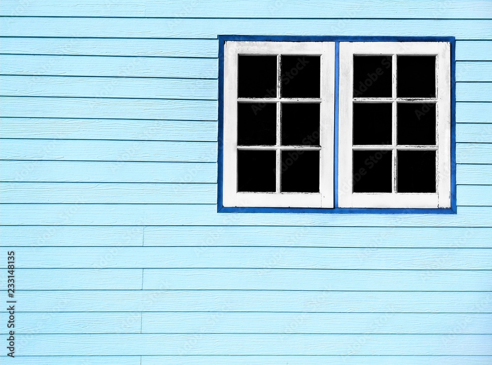 The old white wooden windows on pale blue artificial wood wall background in home decorations concept, vintage style with copy space