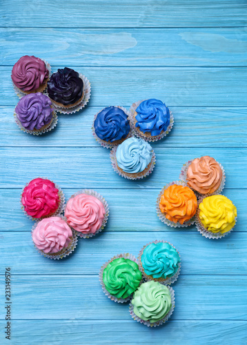 Tasty colorful cupcakes on wooden background