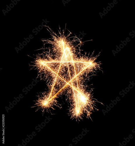 Shining star made of sparklers on dark background