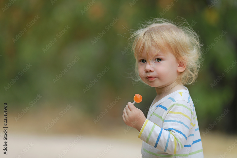 Petit bébé garçon blond en pleine nature avec sa sucette dans la main  Photos | Adobe Stock