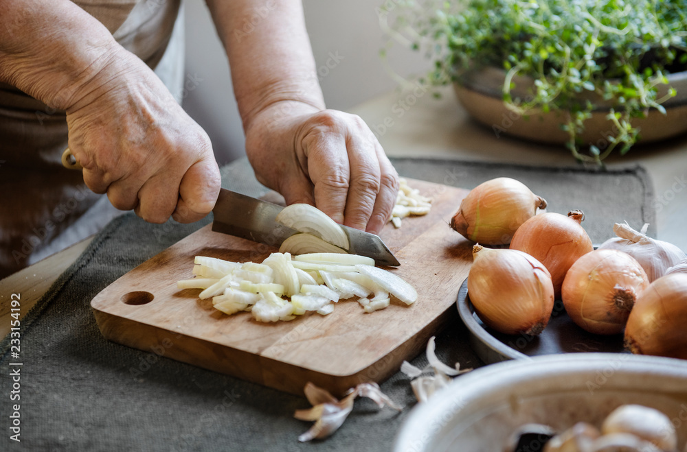 Cook slicing onions on a cutting board Cook slicing onions on a cutting board