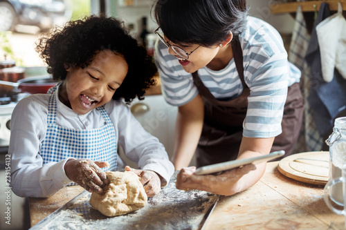 Young boy leaning to bake with his mother