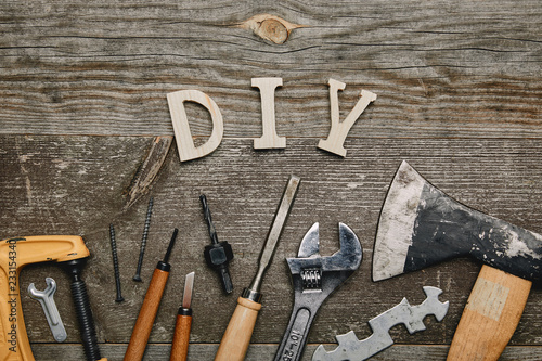 Flay lay with different carpentry tools and diy sign on wooden background photo