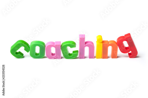closeup of colorful plastic letters on white background - Coaching