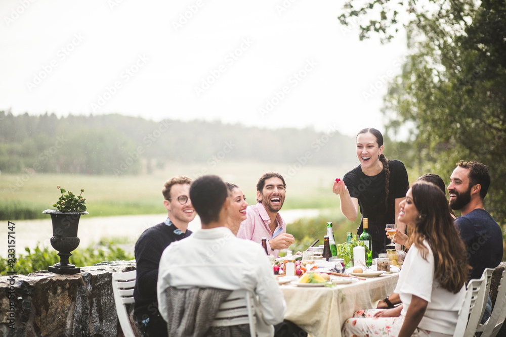 © Maskot - Friends enjoying dinner party in backyard
