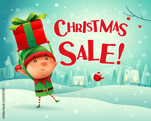 Christmas Sale! Little elf holds up gift present in Christmas snow scene winter landscape.