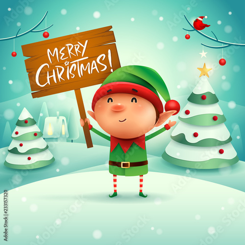 Merry Christmas! Little elf holds wooden board sign in Christmas snow scene winter landscape.