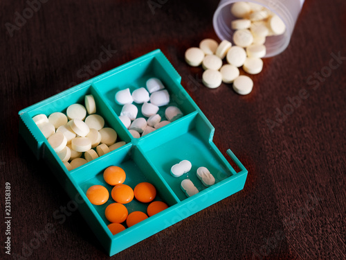 Tablets in a box for drugs, an overturned jar of pills photo