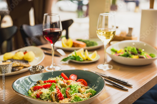 Festive dinner with tasty salads, fish dishes and glass of wine. Healthy food in cafe
