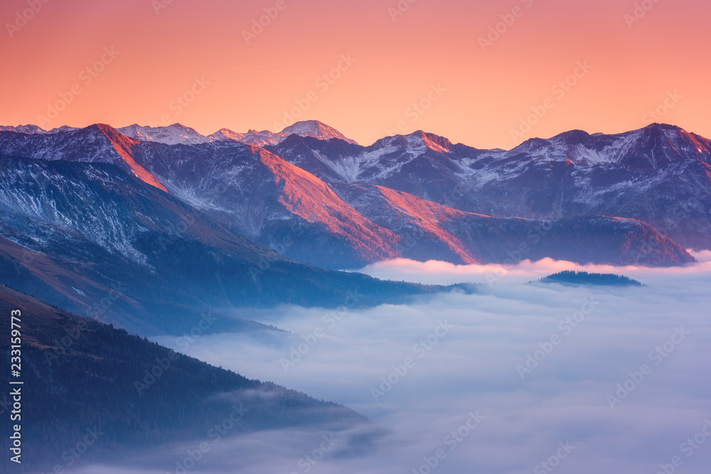 Amazing sunset in Alps mountains over cloud and mountain ridge in sunlight, Hohe Tauern national park, Carinthia, Austria