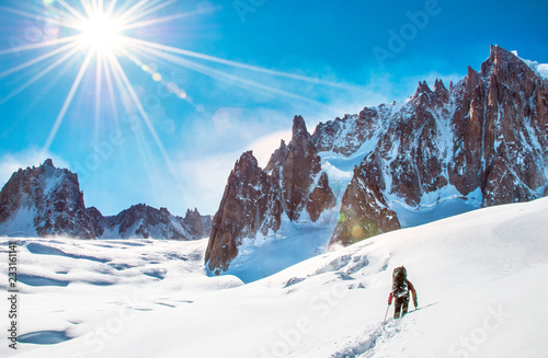 Climber reaches the summit of mountain peak. Climbing and mountaineering sport concept © Andrii Vergeles