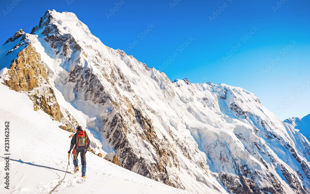 Hiker with backpacks reaches the summit of mountain peak. Success, freedom and happiness, achievement in mountains. Active sport concept. Hiker with backpacks reaches the summit of mountain peak. Success, freedom and happiness, achievement in mountains. Active sport concept.