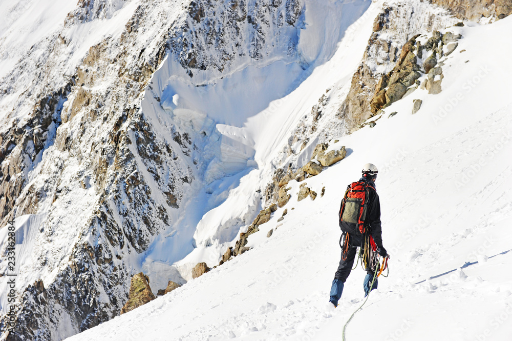 Climber reaches the summit of mountain peak. Climbing and mountaineering sport concept. Climber reaches the summit of mountain peak. Climbing and mountaineering sport concept.