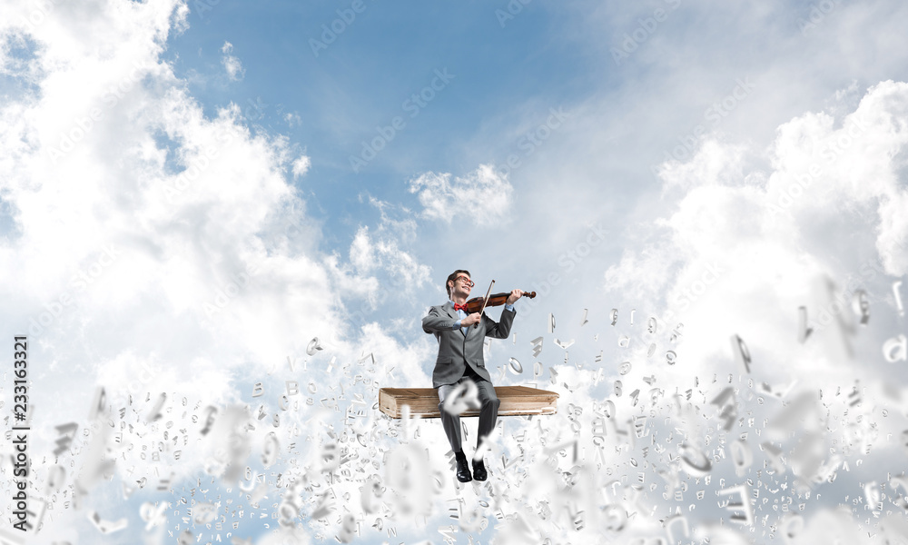 Handsome violinist play his melody and symbols fly around in air