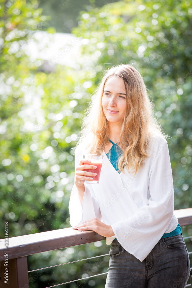 Young woman drinking juice outdoors Young woman drinking juice outdoors