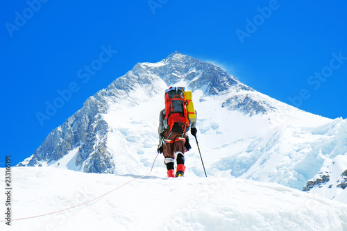 Canvas Print Climber reache the summit of mountain peak