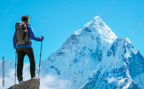 Hiker with backpacks reaches the summit of mountain peak. Success, freedom and happiness, achievement in mountains. Active sport concept.