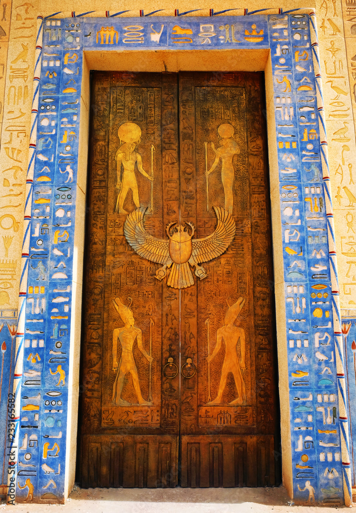 Egyptian hieroglyphs on the door. Hieroglyphic carvings on the exterior walls of an ancient egyptian temple