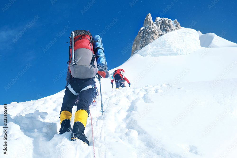 Climber reache the summit of mountain peak. Success, freedom and happiness, achievement in mountains. Climbing sport concept.