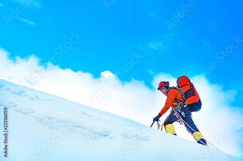 Equipped climber ascent on the top of peak in snowy alpine mountains.  © Andrii Vergeles