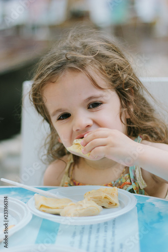 Little girl eating food at ...