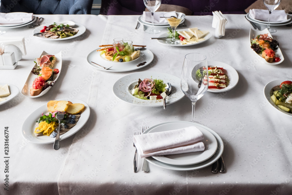 Served for banquet restaurant table with dishes, snack, cutlery, wine and water glasses, european food, selective focus