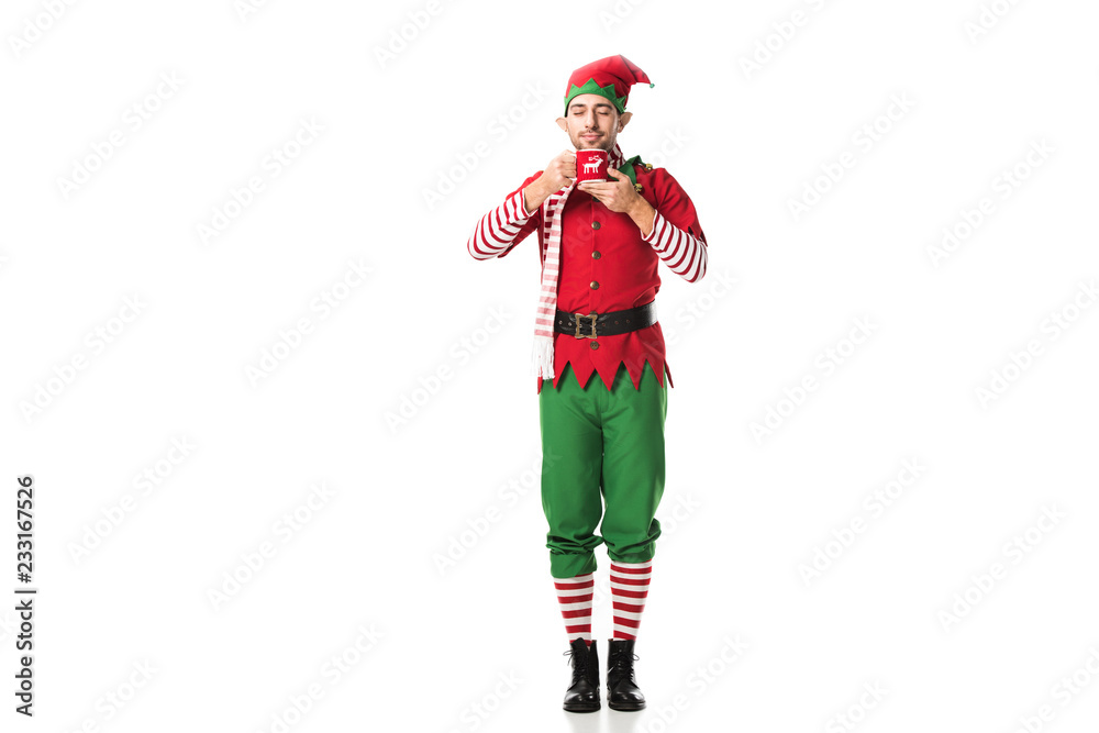 man in christmas elf costume with eyes closed holding cup of tea and inhaling aroma isolated on white