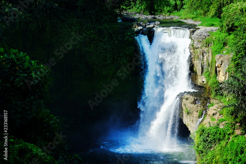 Jumping into the water. Man having fun at waterfalls in the nature. Bali, Indonesia