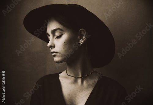 Beautiful  young girl in a stylish felt hat with wide brim sad and nostalgic