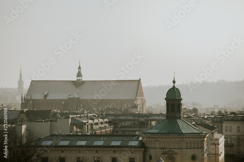 Roofs panorama with towers of the Poland city Kraków during the winter day with grey overcast sky