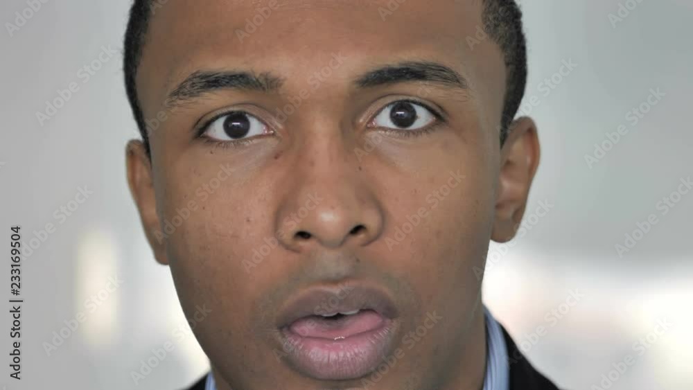 Close Up of Shocked Face of Casual Afro-American Businessman, Astonished by Loss Close Up of Shocked Face of Casual Afro-American Businessman, Astonished by Loss