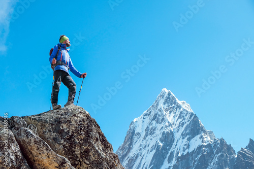 Hiker with backpacks reaches the summit of mountain peak. Success, freedom and happiness, achievement in mountains. Active sport concept. © Andrii Vergeles