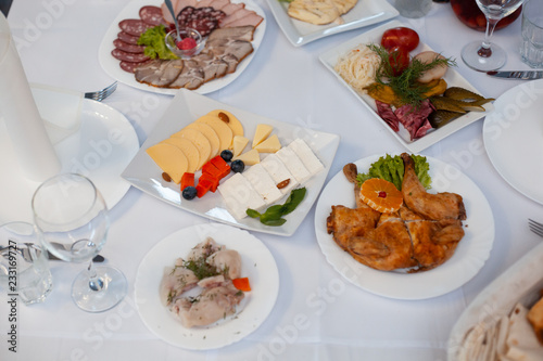 Fotografia The served festive table is covered with a white tablecloth with dishes and drin