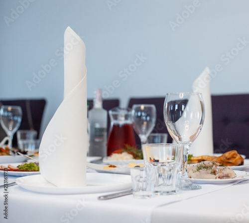 Slika na platnu The served festive table is covered with a white tablecloth with dishes and drin