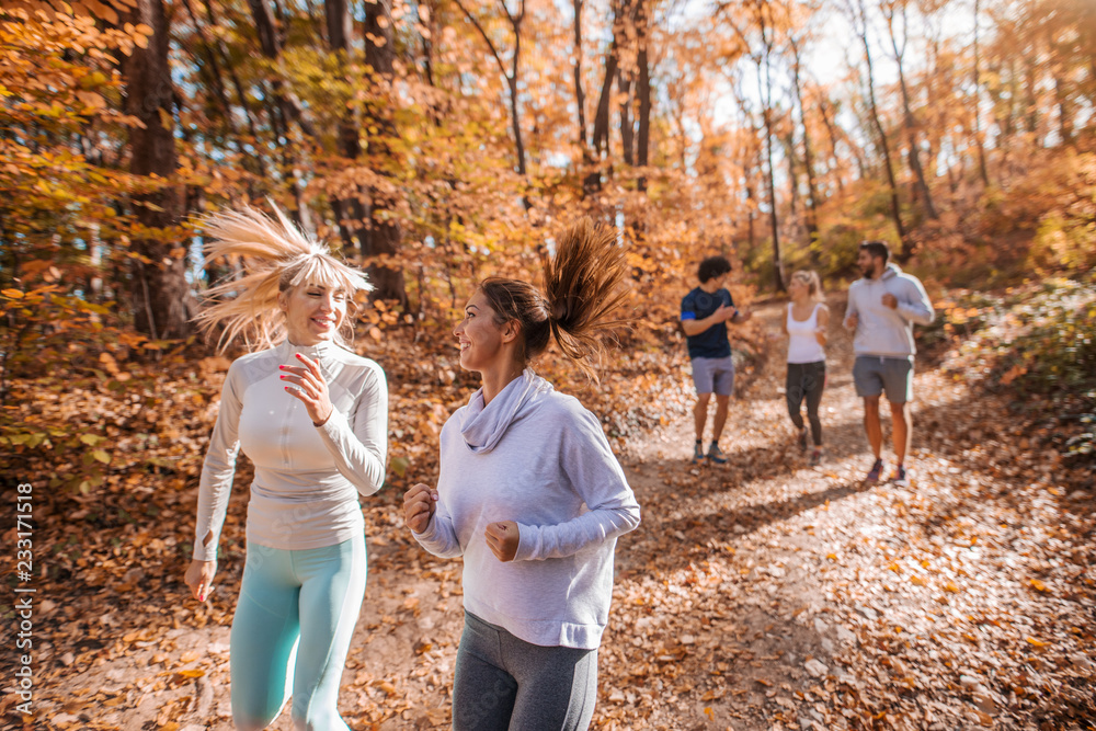 Fototapeta premium Small group of people running in woods.