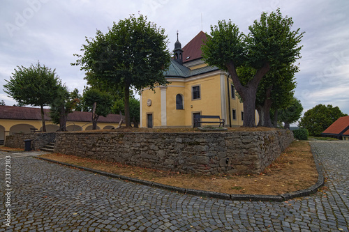 Wide angle landscape view of ancient Church of Our Lady of Carmel in Kostelni Vydri village in cloudy summer day. South Bohemian Region, Czech Republic photo