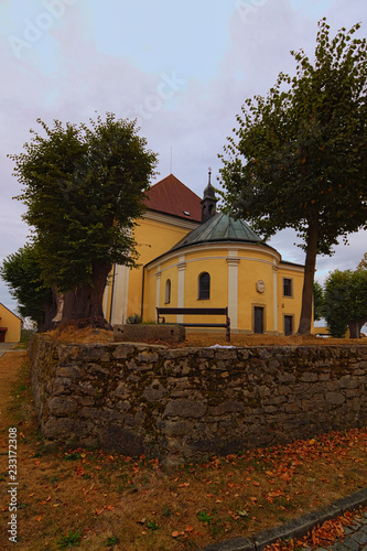 Scenic landscape view of Church of Our Lady of Carmel is surrounded by trees. Kostelni Vydri village in cloudy summer day. South Bohemian Region, Czech Republic photo